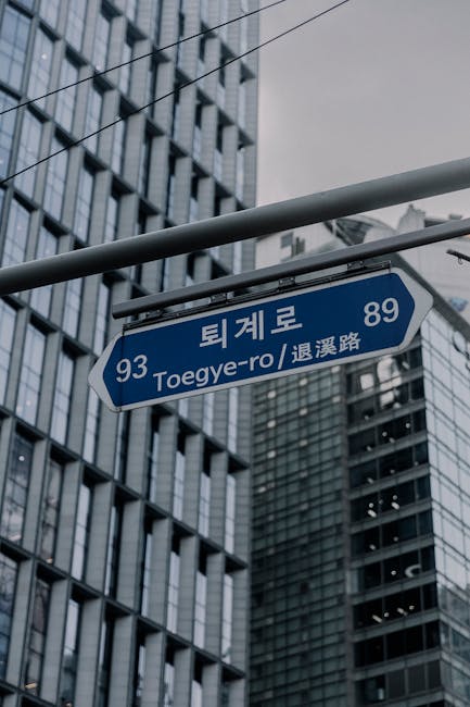 Road name address street sign in Seoul showing Toegye-ro with skyscrapers behind