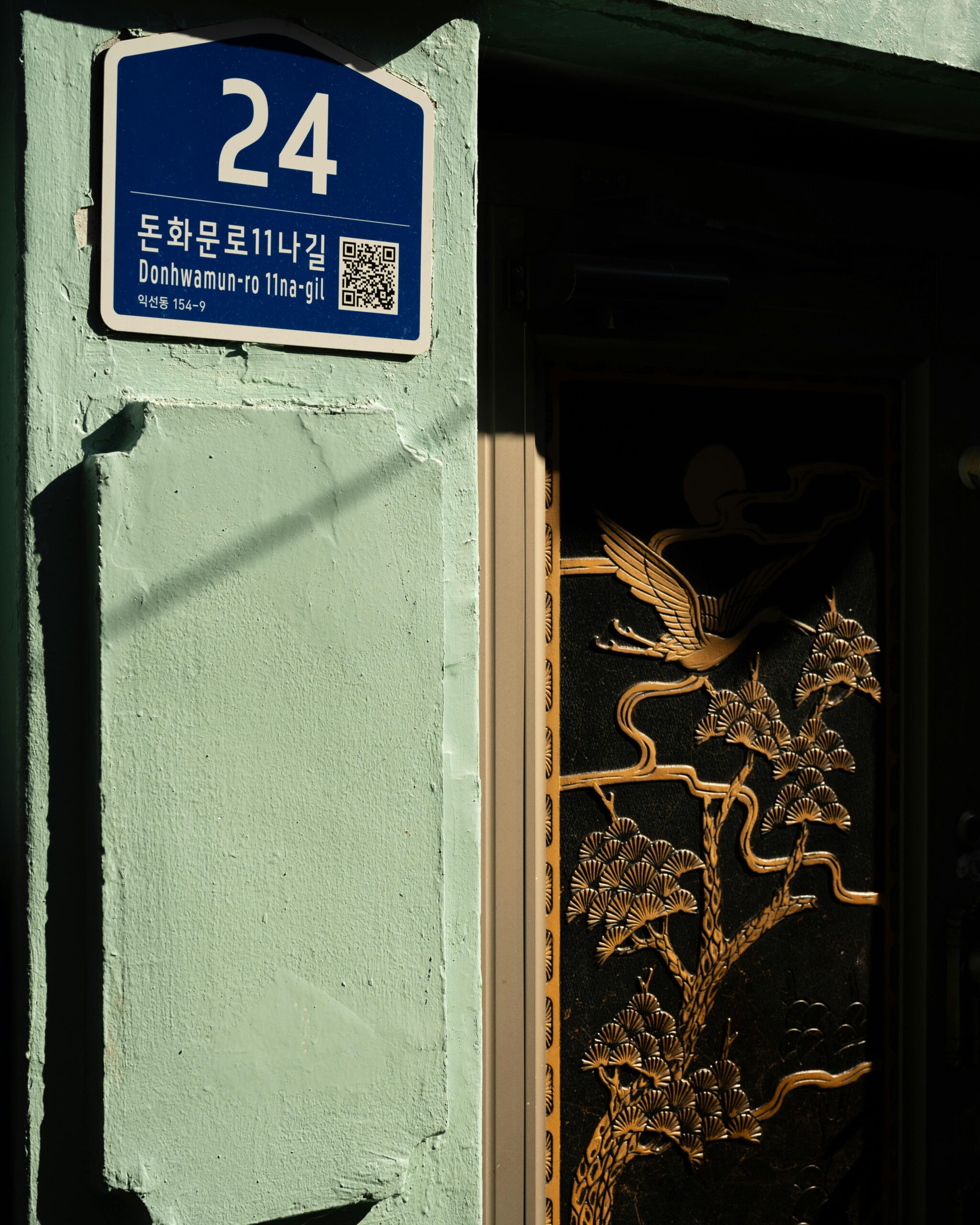 Traditional Korean street sign and door showing old lot number address system in Seoul