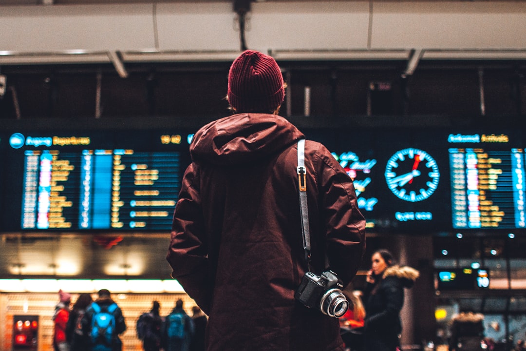 공항 출발 안내판과 실제 운항 정보를 확인하는 해외여행자